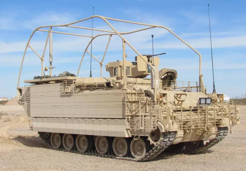 An armored personnel carrier variant of the AMPV with various add-on features, including explosive reactive armor (ERA) tiles along the side and a tubular frame on top to deflect wires and similar hazards. <em>BAE Systems</em>