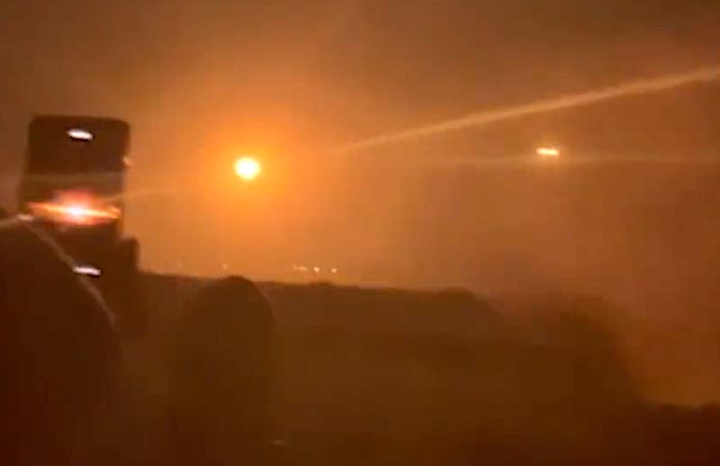 A screen grab from the video showing the target erupting a ball of fire after being hit by the first missile. The second missile is seen approaching from the right. <em>capture via X</em>