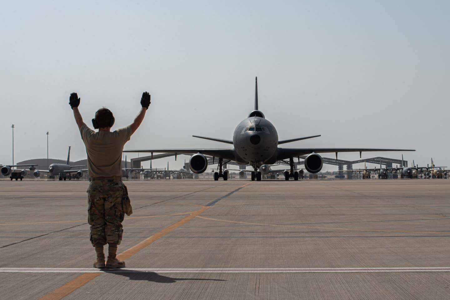 A U.S. airman from the 378th Expeditionary Aircraft Maintenance Squadron directs a taxiing KC-10 Extender assigned to the 908th Air Refueling Squadron at Prince Sultan Air Base, Oct. 3, 2023. <em>U.S. Air Force photo by Tech. Sgt. Alexander Frank</em>
