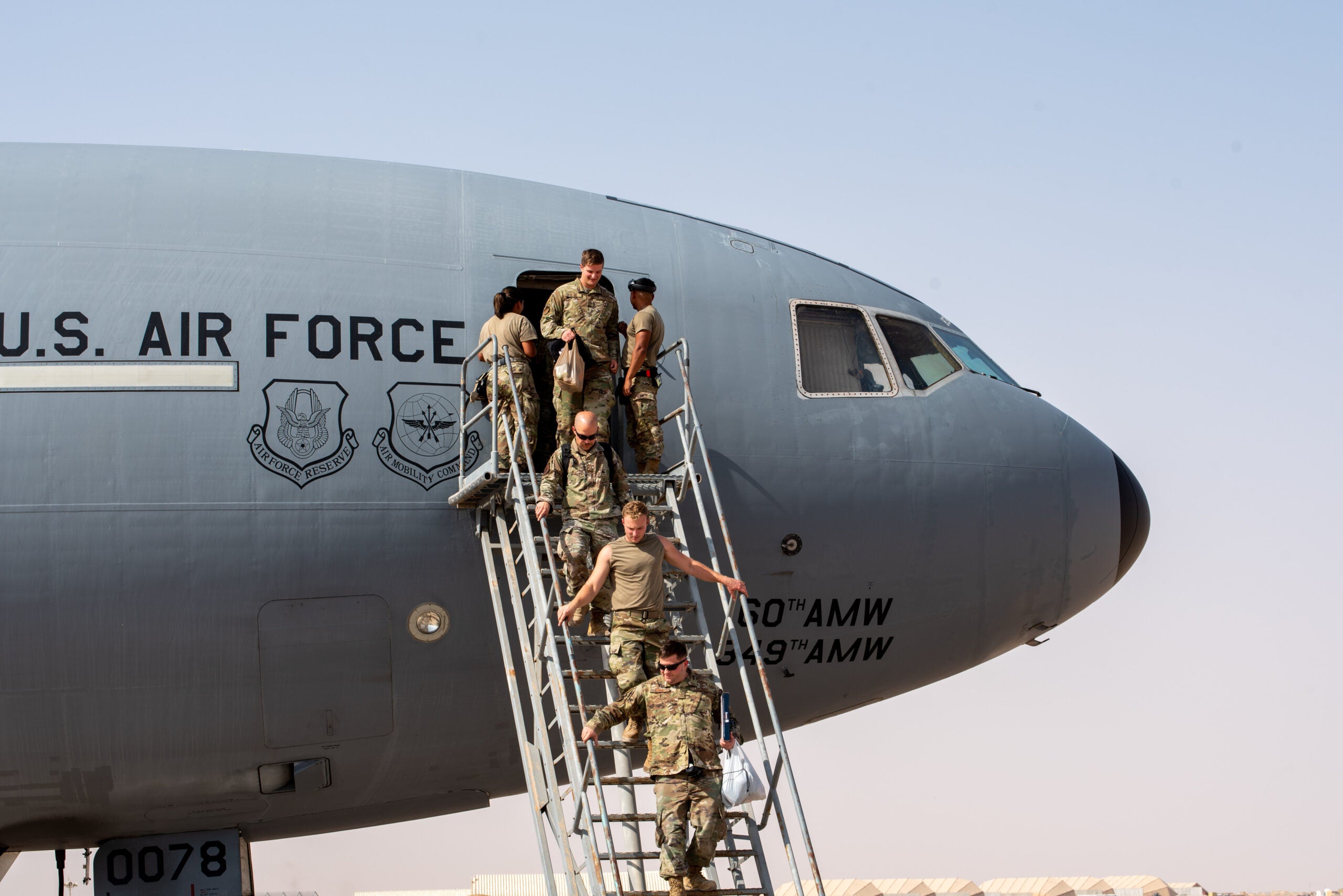 U.S. Airmen from the 908th Air Refueling Squadron exit a KC-10  Extender after the aircraft returned from the airframe's final combat sortie on Prince Sultan Air Base, Oct. 3, 2023. The flight served as a capstone for the KC-10 after over 30 years of service within the U.S. Air Forces Central (AFCENT) Area of Responsibility. By September 2024, the U.S. Air Force's fleet of KC-10s will be decommissioned and gradually replaced by the KC-46 aircraft. (U.S. Air Force photo by Tech. Sgt. Alexander Frank)