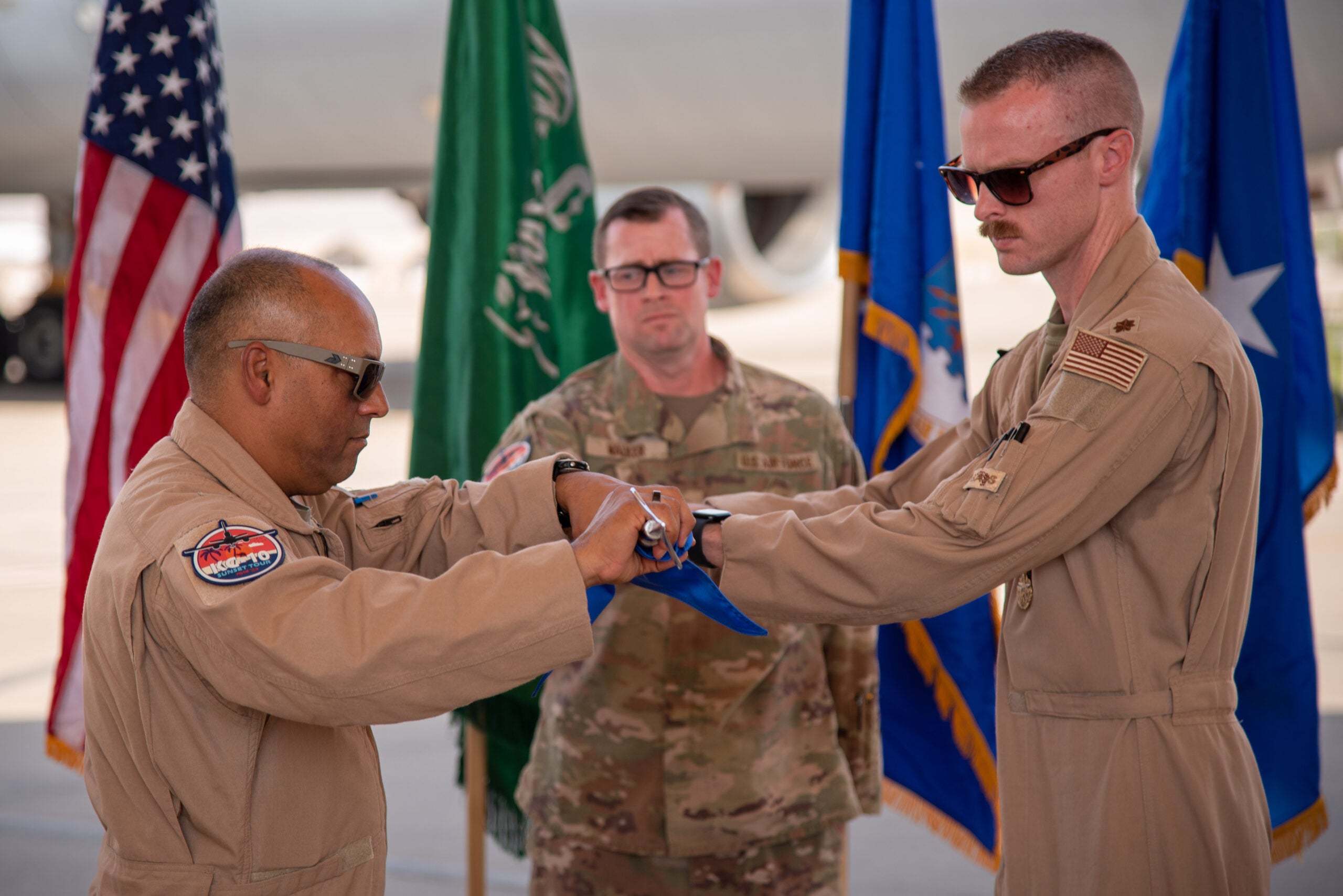 U.S. Air Force Maj. Joseph Rush (right), 908th Expeditionary Air Refueling Squadron (EARS) commander, and Brig. Gen. Akshai Gandhi (left), 378th Air Expeditionary Wing commander, roll-up the 908th EARS guidon during an inactivation ceremony at Prince Sultan Air Base, Kingdom of Saudi Arabia, Oct. 4, 2023. The ceremony highlighted the legacy of the KC-10 after over 30 years of service within the U.S. Air Forces Central (AFCENT) Area of Responsibility. By September 2024, the U.S. Air Force's fleet of KC-10s will be decommissioned and gradually replaced by the KC-46 aircraft. (U.S. Air Force photo by Tech. Sgt. Alexander Frank)