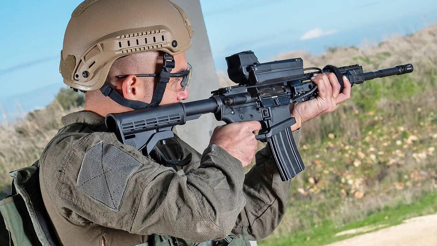 A promotional image showing an individual holding an M4-style carbine equipped with a Smash 2000L/Smash 3000 optic. <em>Smart Shooter</em>