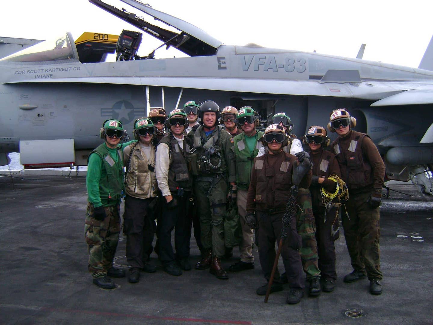 Scott with ground crew on the boat, his F/A-18 wearing the Battle E award insignia. (Scott "Intake"<br>Kartvedt)