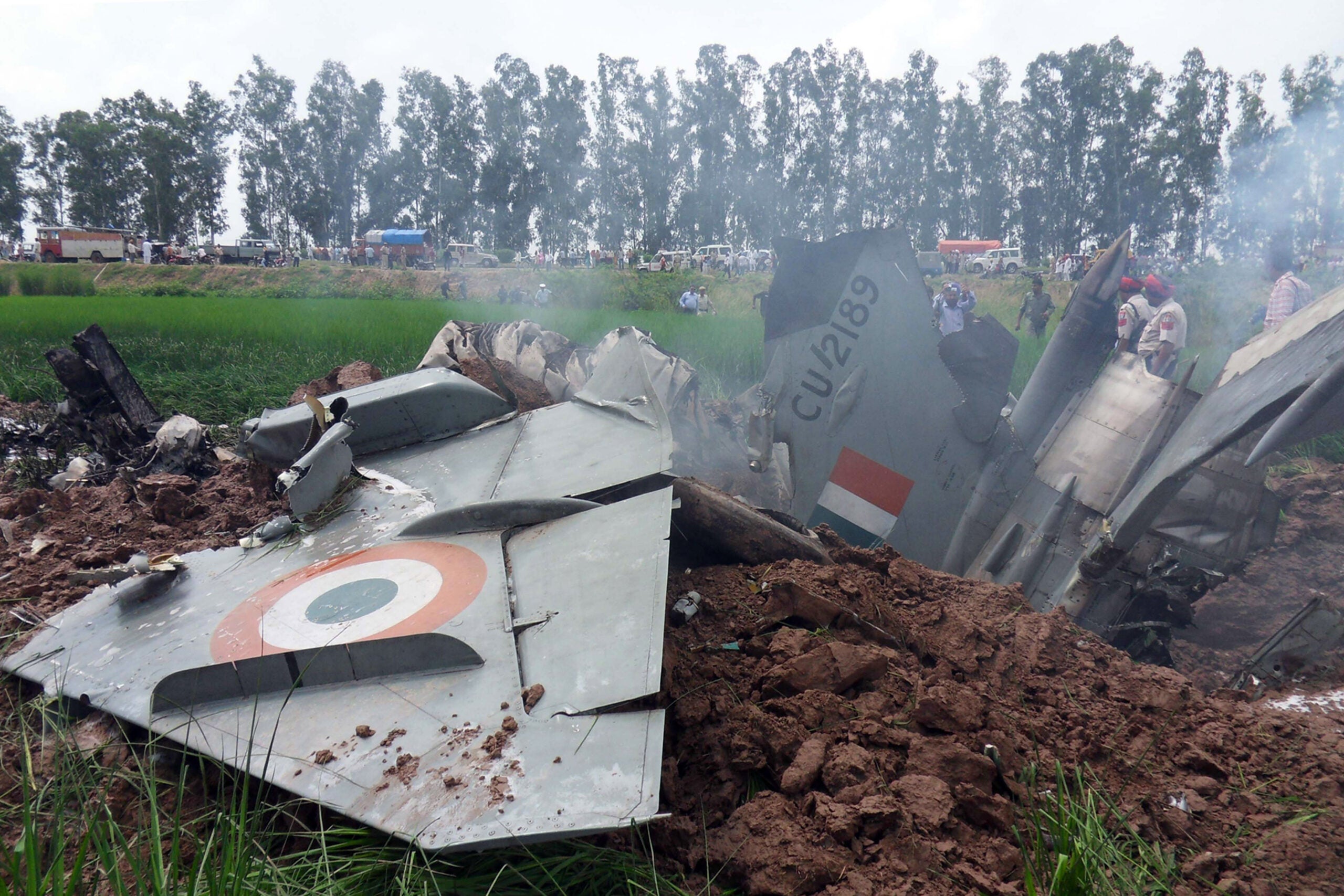 Indian Air Force personnel stand by the wreckage of a MiG-21 aircraft that crashed in a field in Rajgarh, in Patiala district on September 6, 2011. An Indian air force MiG-21 fighter jet crashed in the northern state of Punjab, the pilot ejected safely, causing no casualties. The Russian-designed jet came down near the town of Rajpura, some 30 kms from Patiala. AFP PHOTO/STR (Photo credit should read STR/AFP via Getty Images)