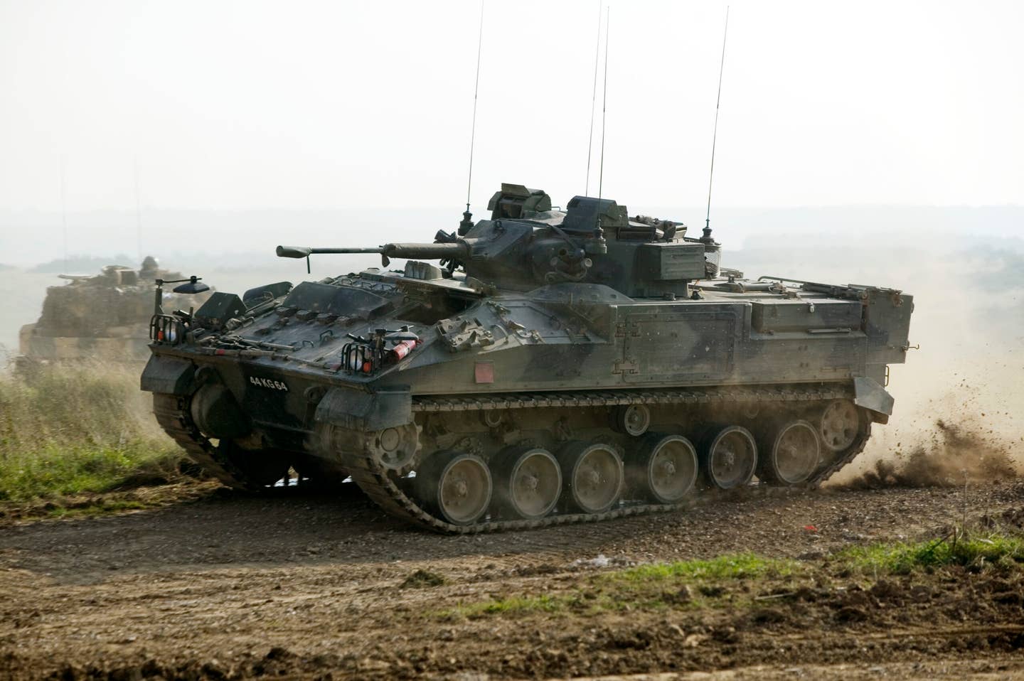 A Warrior IFV is put through its paces at a firepower demonstration at Warminster, Salisbury Plain. Note the full set of six road wheels, idler, and three track return rollers. <em>Crown Copyright</em>