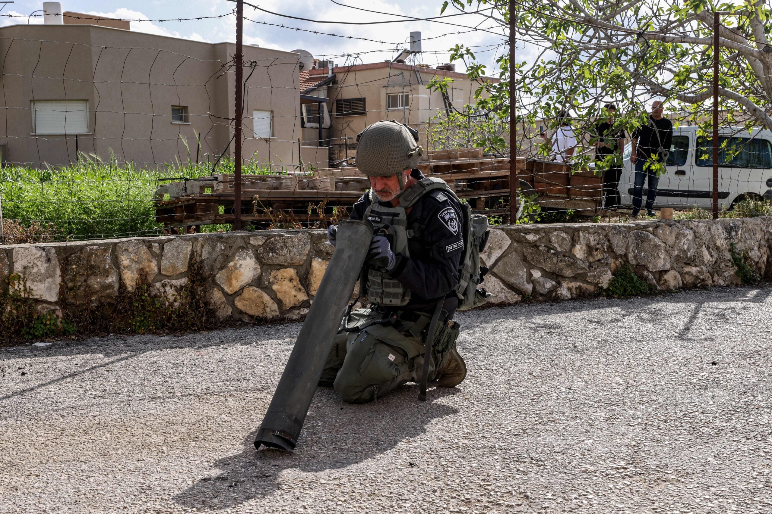 An Israeli police bomb disposal unit member inspects the remains of a shell fired from Lebanon on Israel in its northern town of Fassuta on April 6, 2023. - The Israeli army said it intercepted rocket fire from Lebanon on April 6 after clashes between Israeli police and Palestinians inside Islam's third-holiest site drew warnings of retaliation from around the region. (Photo by Jalaa MAREY / AFP) (Photo by JALAA MAREY/AFP via Getty Images)