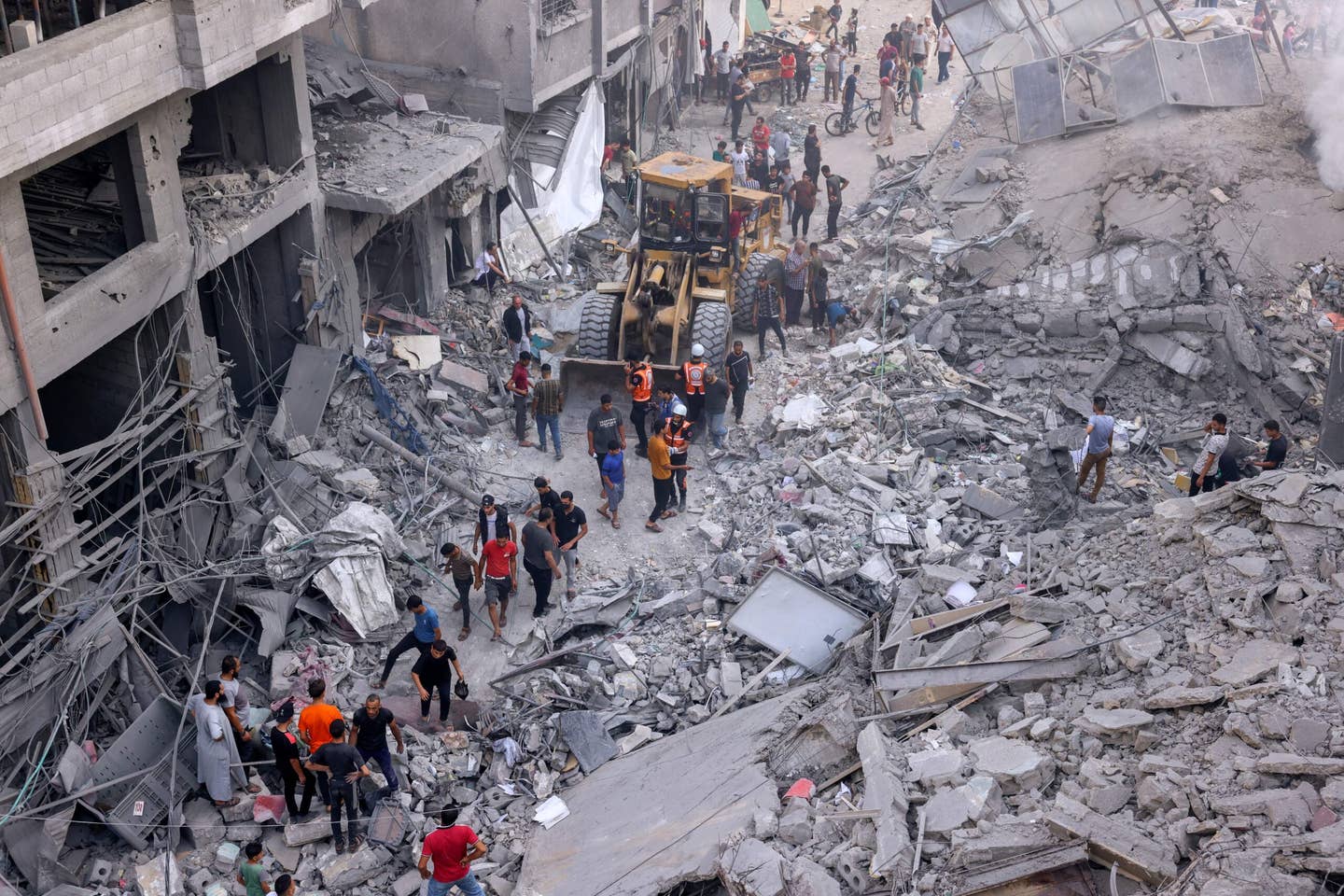 Palestinian civilians and rescuers help clear the rubble in the heavily bombarded city center of Khan Yunis in the southern Gaza Strip following overnight Israeli shelling, on October 10, 2023. (Photo by SAID KHATIB/AFP via Getty Images)