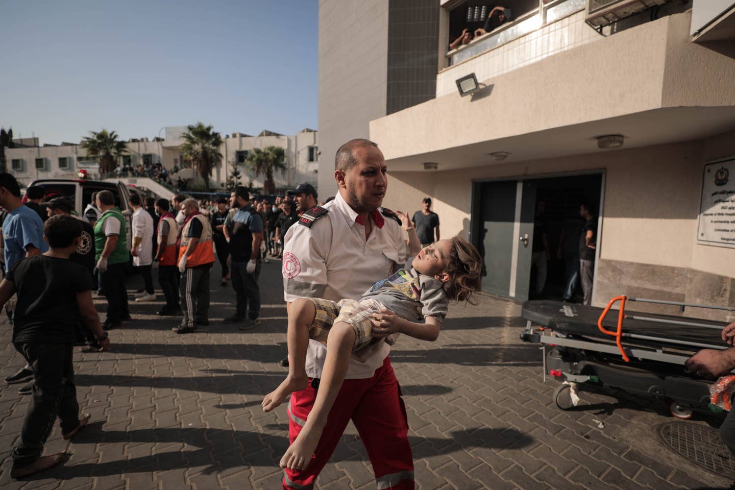 A paramedic carrying a young child with injuries arrives at Al-Shifa hospital, Gaza City, on October 12, 2023. (Photo by Loay Ayyoub for <em>The Washington Post</em> via Getty Images)