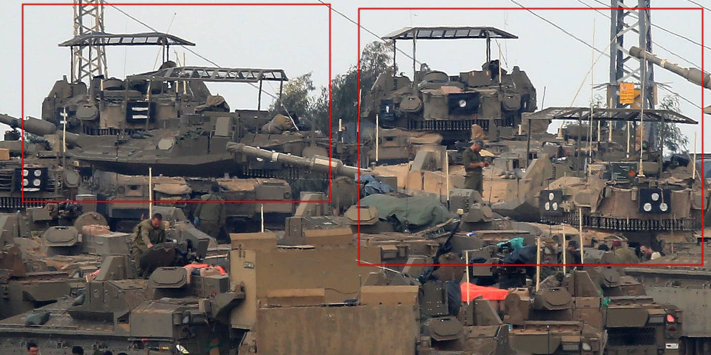 Israeli Merkava tanks, some with "cope cage" style armor screens on top of their turrets, mass near Gaza.