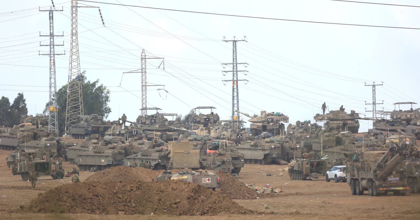 Israeli Merkava tanks and other vehicles in Ashkelon, Israel, near the Gaza Strip on October 16, 2023. Note that not all of the Merkavas have armor cages installed on top of their turrets. <em>Saeed Qaq/Anadolu via Getty Images</em>