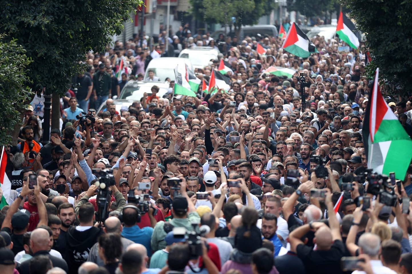 In Ramallah in the West Bank,  people, holding flags and shouting slogans, gather for a protest against yesterday's explosion at the Al-Ahli Baptist Hospital that Hamas blames on Israel, and Israel blames on the Palestinian Islamic Jihad. (Photo by Issam Rimawi/Anadolu via Getty Images)