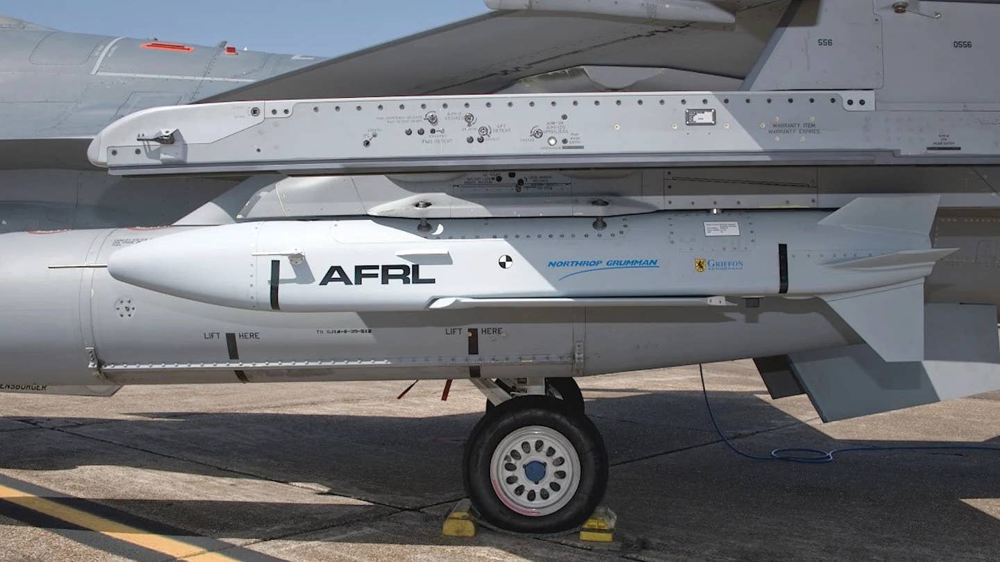 A Gray Wolf test article, designed by Northrop Grumman and powered by a TDI-J85 engine, under the wing of an US Air Force F-16 Viper. <em>USAF</em>