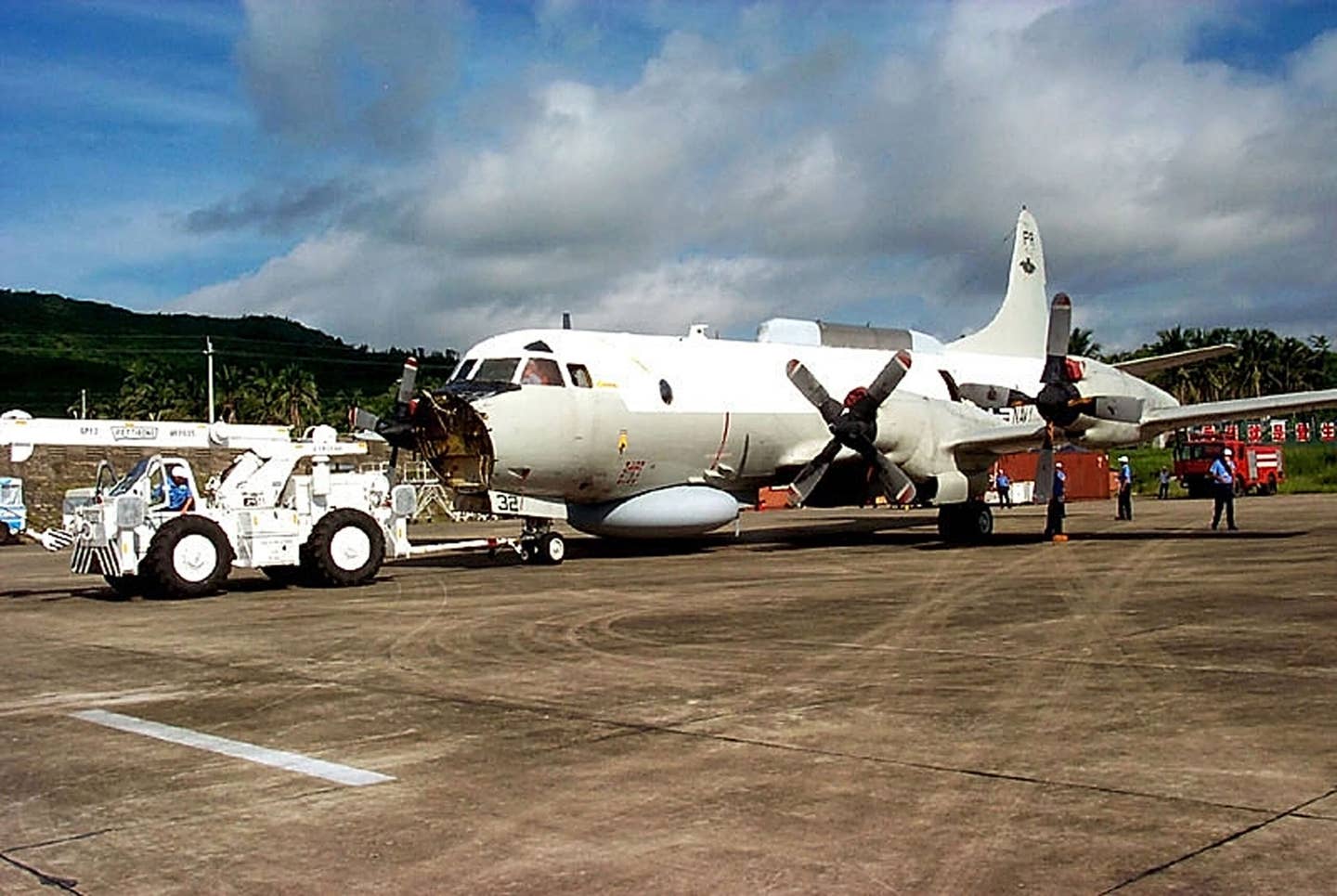 A Lockheed Martin recovery team member repositions the EP-3E Aries II aircraft at Lingshui Airfield, in Hainan, China, on June 18, 2001. The Fleet Reconnaissance Squadron One (VQ-1) aircraft was involved in a mid-air collision with a Chinese J-8 fighter on April 1, 2001 and made an emergency landing on Hainan Island, where it remained until disassembly and removal operations began. The aircraft was disassembled and returned to the United States. <em>Photo Courtesy of Lockheed Martin Aeronautics Co./U.S. Navy via Getty Images</em>