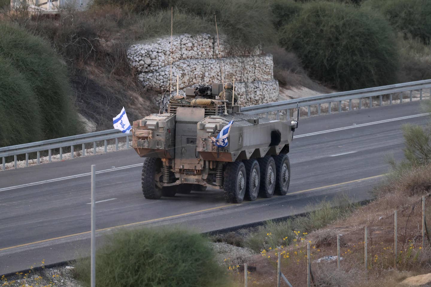 A picture taken from the southern Israeli city of Sderot shows an Eitan 8x8 armored fighting vehicle advancing on a road by the Gaza border, on October 29, 2023. <em>Photo by JACK GUEZ/AFP via Getty Images</em>