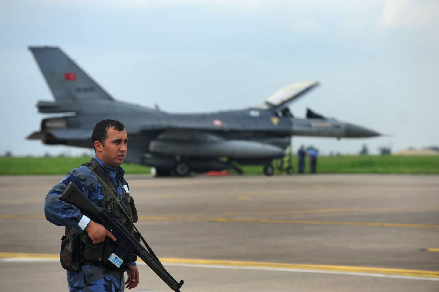 A soldier guards a Turkish Air Force F-16 during an exercise at Incirlik Air Base, Turkey, in 2013. <em>U.S. Air Force photo by Senior Airman Anthony Sanchelli</em>