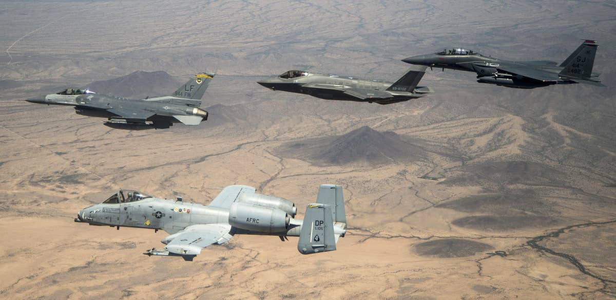 An A-10 Warthog, at bottom left, flies together with, at top, left to right, an F-16C Viper, an F-35A Joint Strike Fighter, and an F-15E Strike eagle. <em>USAF</em>