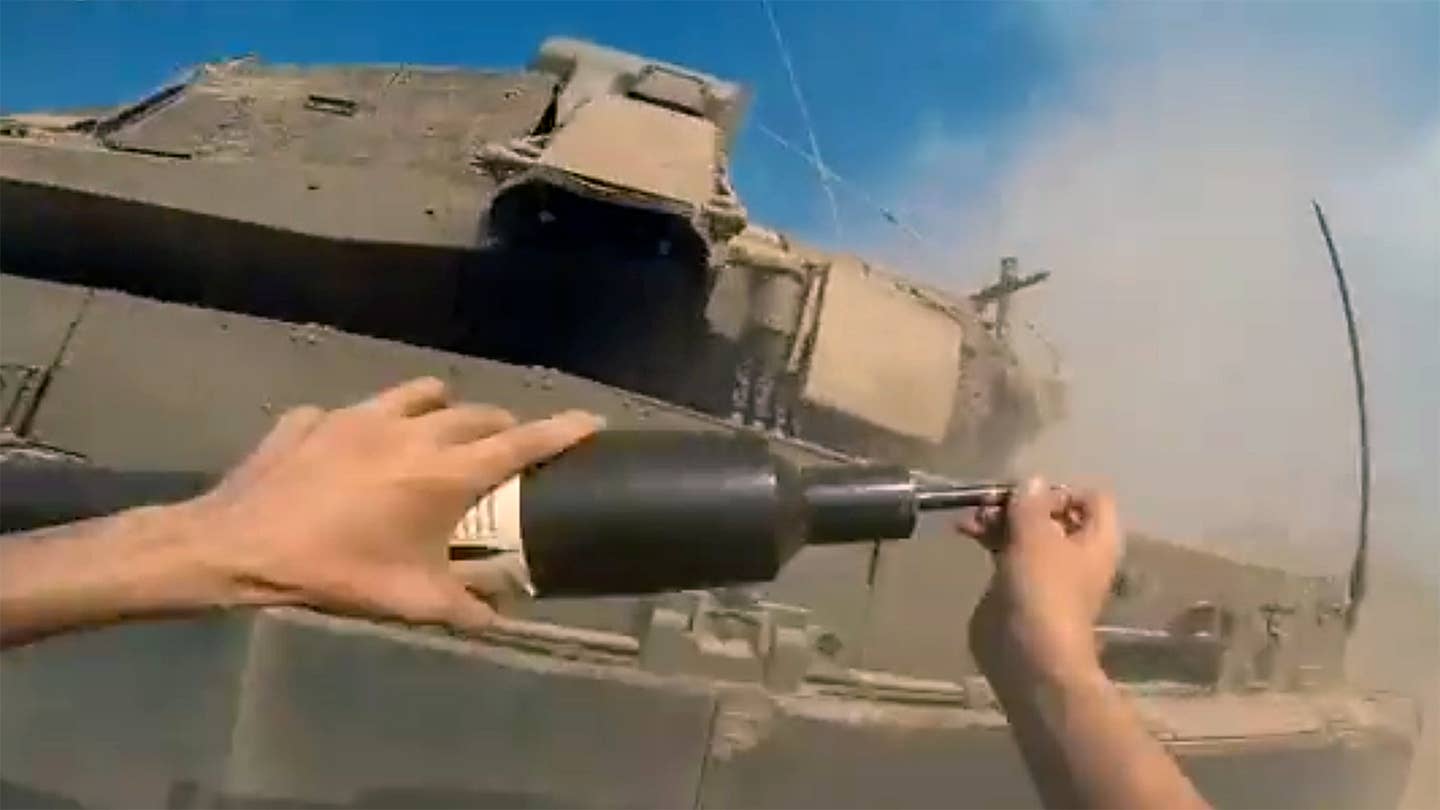 Wild new video shows a Hamas fighter run toward an Israeli tank and place an IED on it.