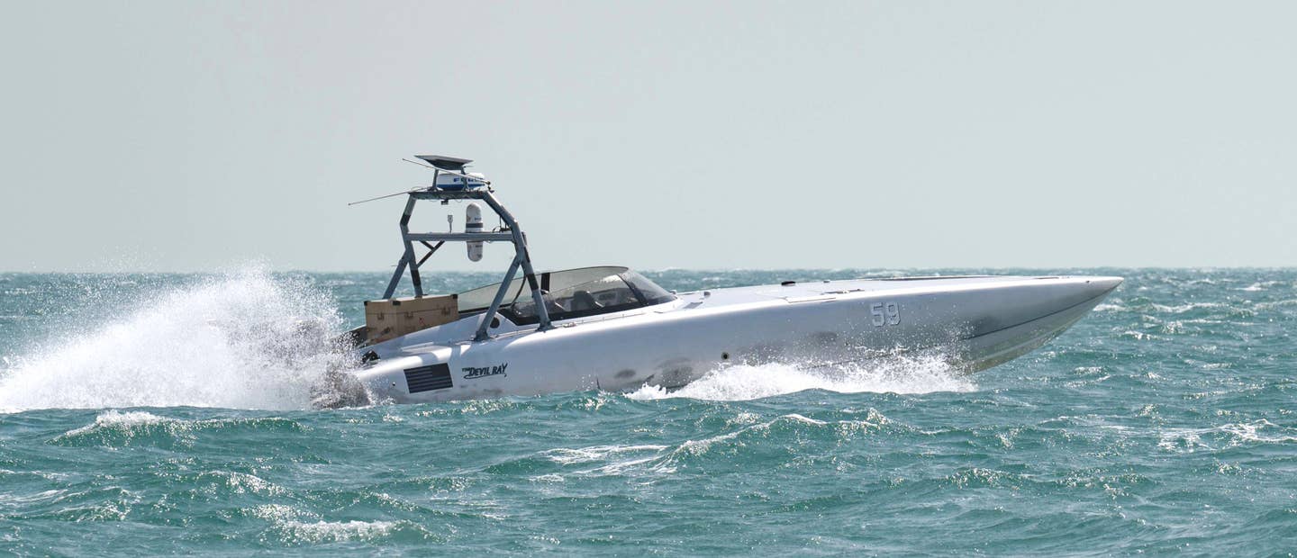 A picture of the T38 USV used during last weeks test with the Switchblade launcher, painted tan, visible at the rear. At the rear there is also a frame with, from the top down, what looks to be a Starlink antenna, a small commercial navigation radar, and a pair of sensor turrets. <em>USN</em>