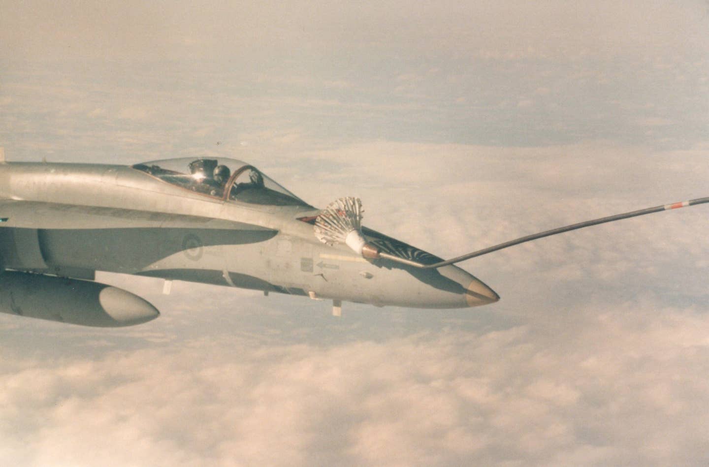 A 'tip-off' in a Hornet. Notice how the probe has hit the basket off-center, causing it to bend. In a moment, the 300-lb basket is likely to hit the Hornet. No, that’s not me – I took the picture from a 707 tanker window. <em>Dan McWilliams</em>