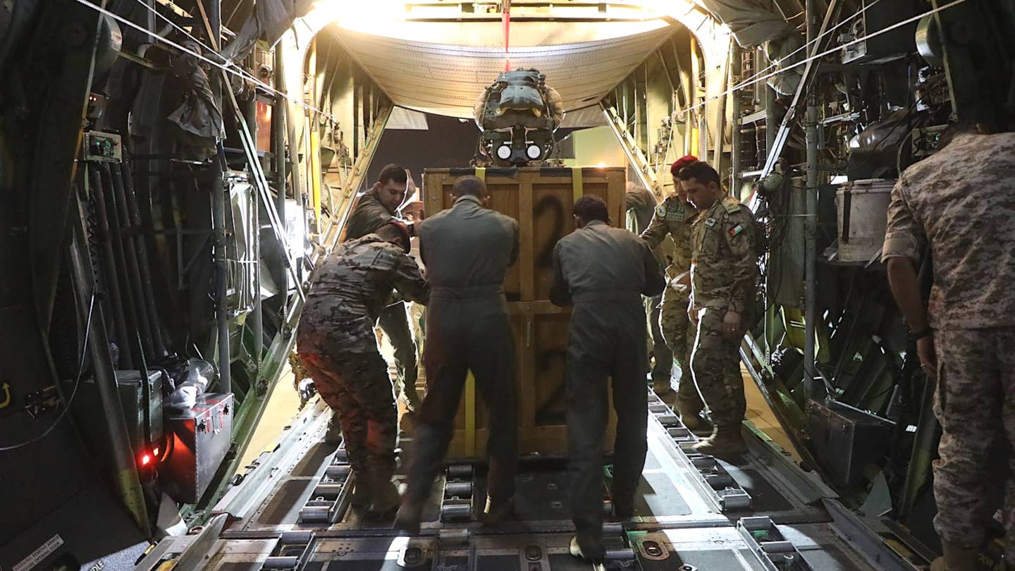 Jordanian personnel load a pallet of aid onto a C-130 ahead of the airdrop over Gaza. The parachute system can be seen on top and the two prominently visible circular features on the side are indicative of the U.S. JPADS. <em>Jordanian Armed Forces</em>