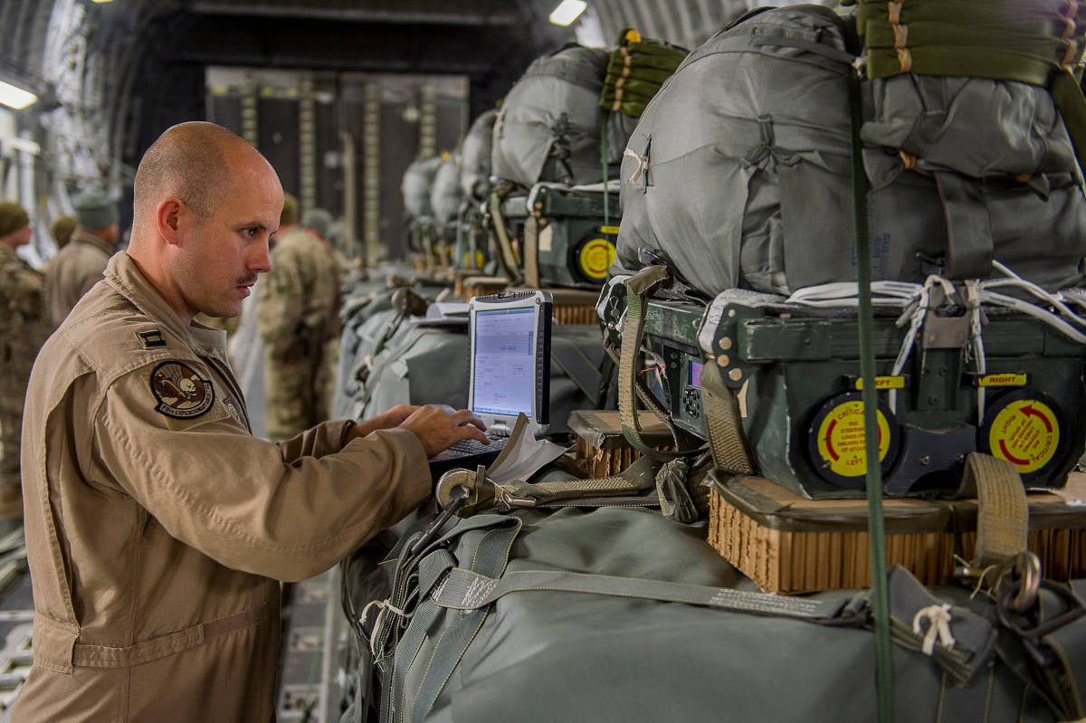 A member of the US Air Force programs a JPADS-equipped airdrop load onboard a C-17 flying over Afghanistan in 2013. The same circular features as are seen in the recent Jordanian armed forces pictures of the aerial resupply operation over Gaza can be plainly seen here. <em>USAF</em>