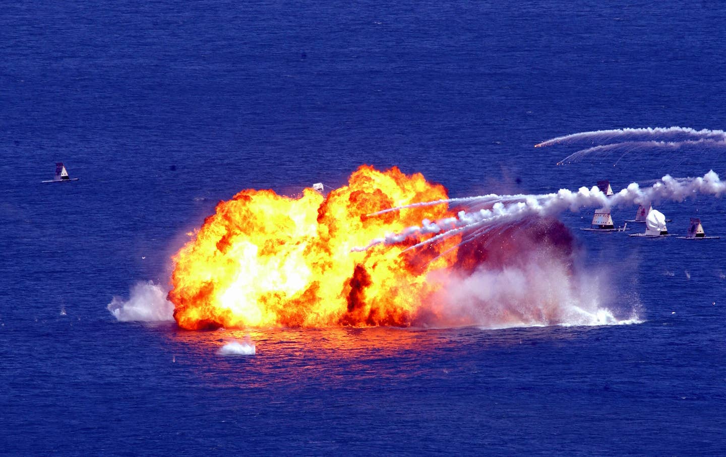 ROCAF F-5Es (out of picture) drop napalm tanks on mock targets at sea in simulated wargames off Li Tse Chien, northeastern Ilan county, in September 2003. <em>SAM YEH/AFP via Getty Images</em>
