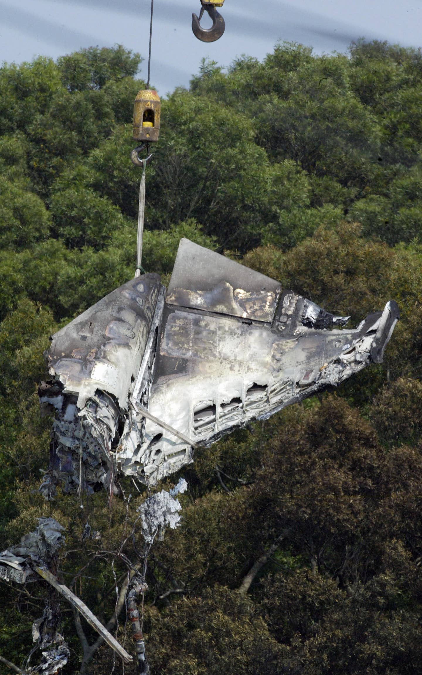 The wreckage of a crashed F-5F is lifted by a crane in Hsinchu, northern Taiwan, on May 11, 2007. Two Taiwanese fighter pilots and two Singaporean servicemen were killed when an F-5F jet crashed into a military compound during an exercise. <em>STR/AFP via Getty Images</em>