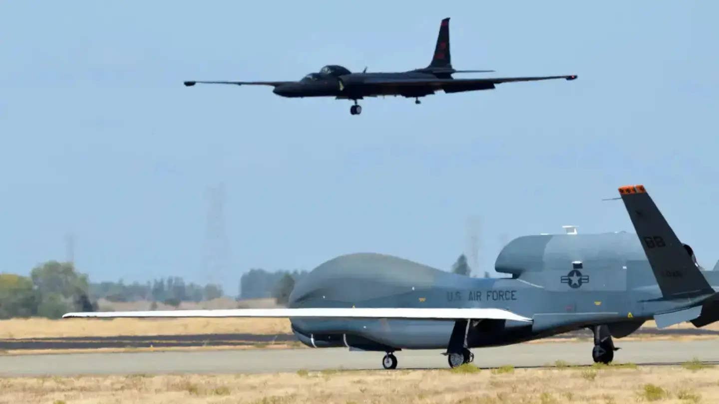 A TU-2S comes in to land while an RQ-4 Global Hawk sits in the foreground. <em>USAF</em>