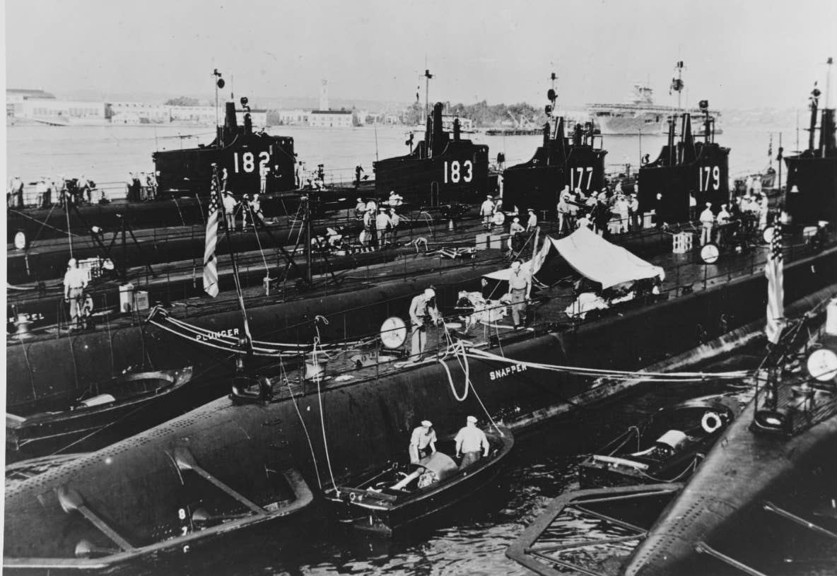 Moored at San Diego, California, nested alongside submarine tender <em>Holland</em>, from which this photograph is taken, are (left to right): <em>Salmon</em>; <em>Seal</em>; <em>Pickerel</em>; <em>Plunger</em>; <em>Snapper</em>; and <em>Permit</em>, 1940. <em>Naval History and Heritage Command</em>