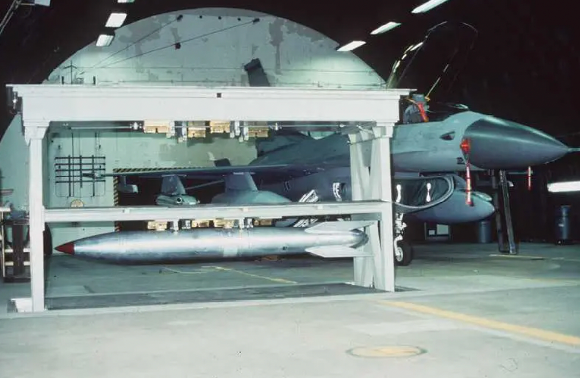 A Weapons Storage and Security System vault in the raised position and holding an earlier model of&nbsp;B61 nuclear bomb. The vault is within a&nbsp;Protective Aircraft Shelter.&nbsp;<em>Public Domain/WikiCommons</em>