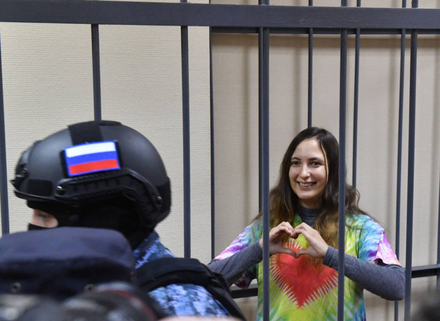 Russian artist Alexandra Skochilenko, 33, accused of spreading disinformation about the Russian Army for changing supermarket price tags with messages criticizing the Russian military offensive in Ukraine, gestures from inside a defendants’ cage during her verdict hearing at a court in Saint Petersburg on November 16, 2023. <em>Photo by OLGA MALTSEVA/AFP via Getty Images</em>