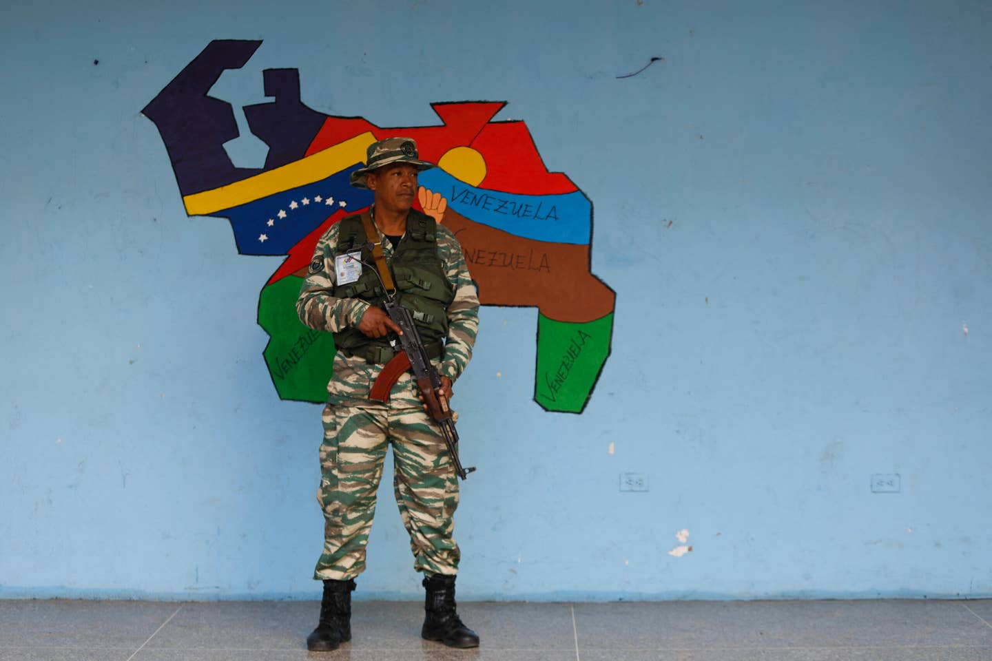 A member of the Bolivarian Militias stands guard at a polling station during a consultative referendum on Venezuelan sovereignty over the Essequibo region controlled by neighboring Guyana, in Caracas on December 3, 2023. <em>Photo by PEDRO RANCES MATTEY/AFP via Getty Images</em>