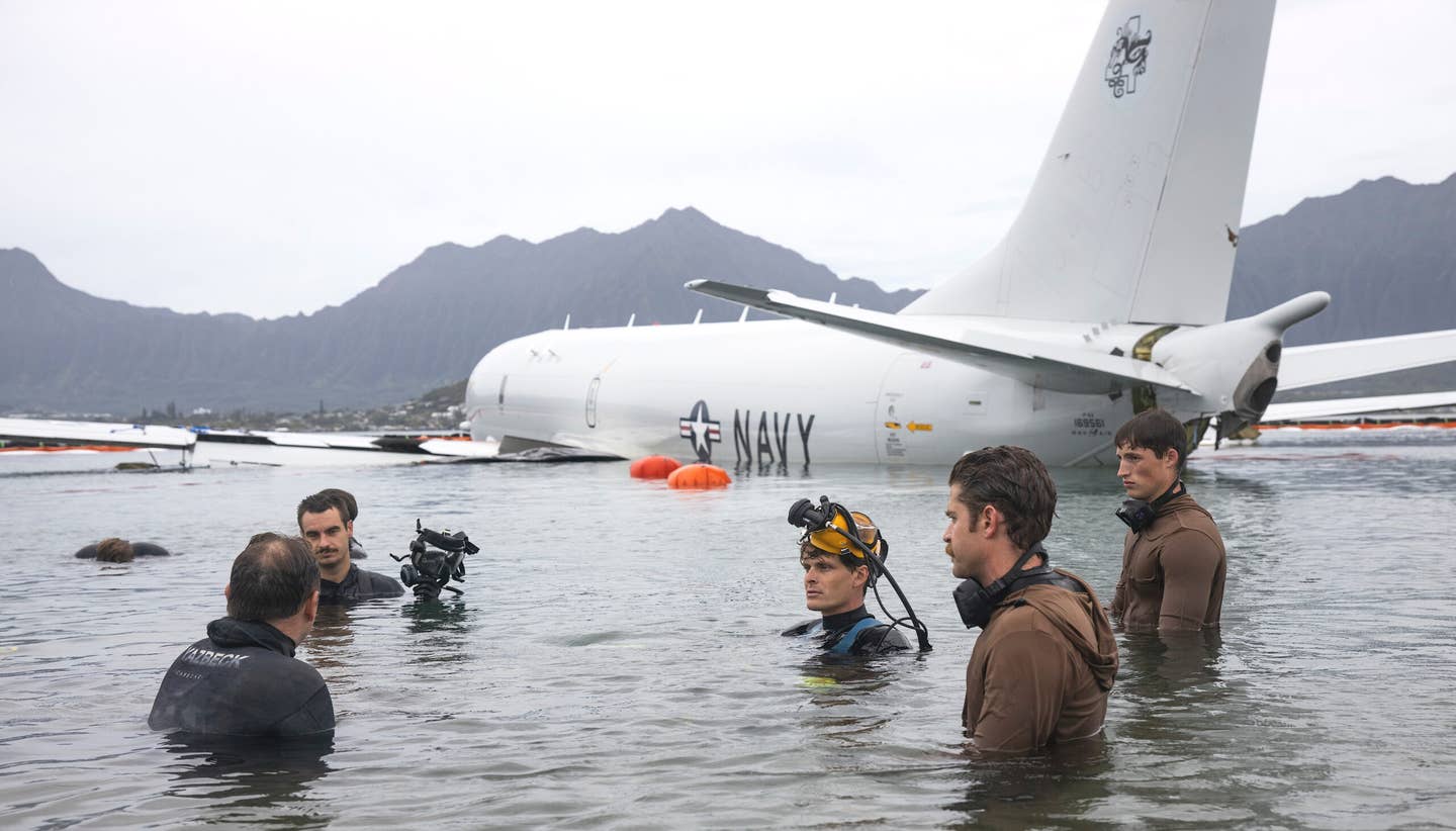 Navy divers confer on Friday, December 1, about preparations to float the P-8A from its resting place in Kaneohe Bay. <em>USN</em>