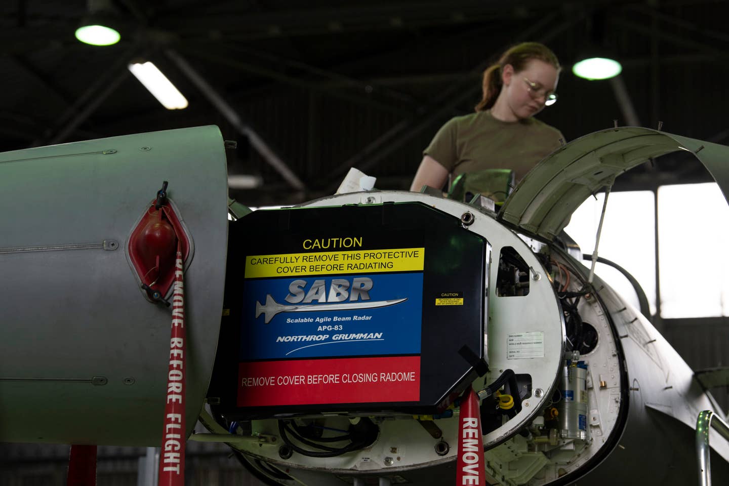A U.S. Air Force F-16 avionics apprentice works to install a new SABR active electronically scanned array (AESA) radar onto an F-16C at Spangdahlem Air Base, Germany, May 20, 2022. <em>U.S. Air Force photo by Tech. Sgt. Maeson L. Elleman</em>
