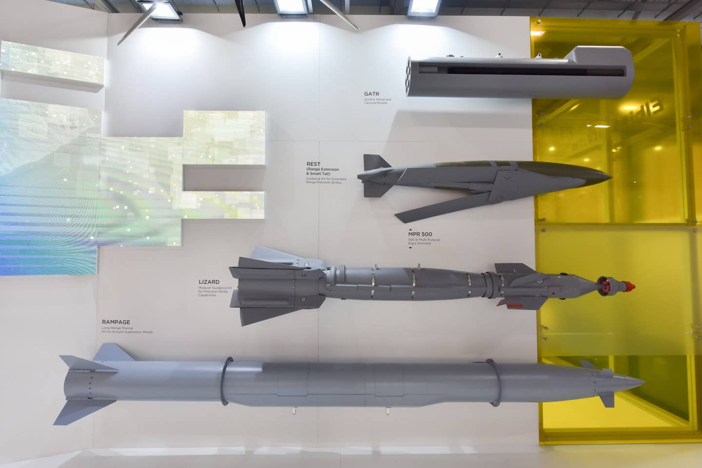 A model of the Rampage missile (bottom) displayed during the Farnborough International Airshow in England in July 2022. Arranged above it are the Guided Advanced Tactical Rocket (GATR), Range Extension and Smart Tail (REST) kit, and the Lizard precision-guided bomb. <em>Photo by John Keeble/Getty Images</em>