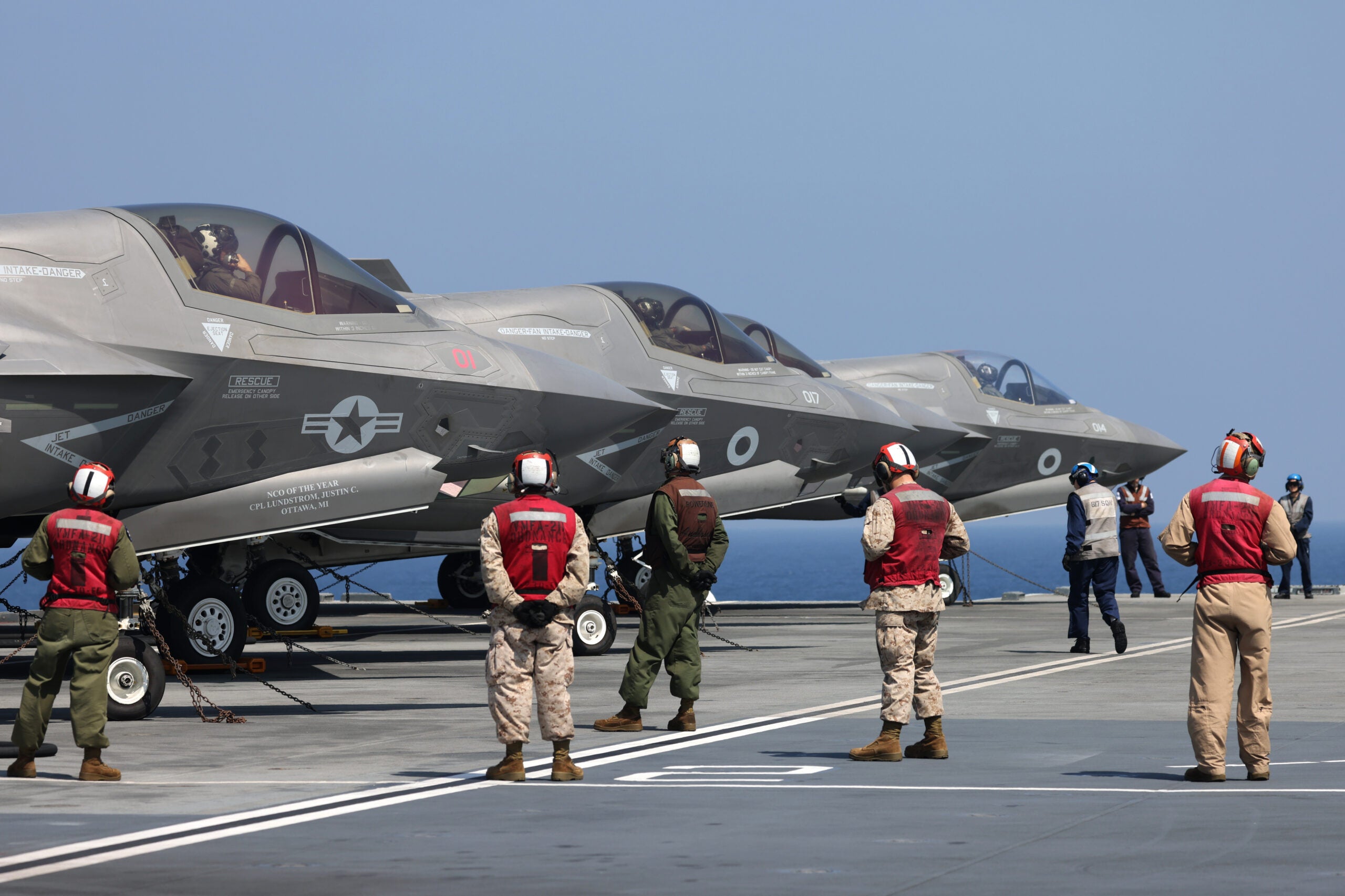Pictured: UK and US F-35B Lightning Jets (and their UK and US deck crew) prepare to take off from HMS Queen Elizabeth to cross deck to USS Essex

On 8th November 2021, aircraft from HMS Queen Elizabeth and USS Essex cross deck while in the Arabian Sea. 

Marine Fighter Attack Squadron (VMFA) 211 cross-decked F35-B Lightning Jets from HMS Queen Elizabeth to amphibious assault ship USS Essex. Simultaneously, MV-22B Osprey, UH-1Y Venoms and AH-1Z Vipers from USS Essex crossed deck to HMS Queen Elizabeth. 

Aircraft attached to Marine Medium Tiltrotor Squadron (VMM) 165 (Reinforced), 11th Marine Expeditionary Unit, landed on HMS Queen Elizabeth demonstrating increased interoperability, information sharing, and expanded access across the region as allies, as well as credible and capable forces operating in the U.S. 5th Fleet area of operations.

HMS Queen Elizabeth is the deployed flag ship for Carrier Strike Group 21(CSG21). CSG21 will see the ship along with the Strike Group work with over 40 countries from around the world. The Strike Group will operate and exercise with other Countries Navies and Air Forces during the 7 month deployment. 

The Strike Group includes ships from the United States Navy, The Dutch Navy, and Marines from the US Marine Corps. As well as UK Frigates, Destroyers two RFA supply ships and air assets from 617 Sqn, 820 NAS, 815 NAS and 845 NAS. This will be the largest deployment of Fifth Generation Fighter Jets in history.