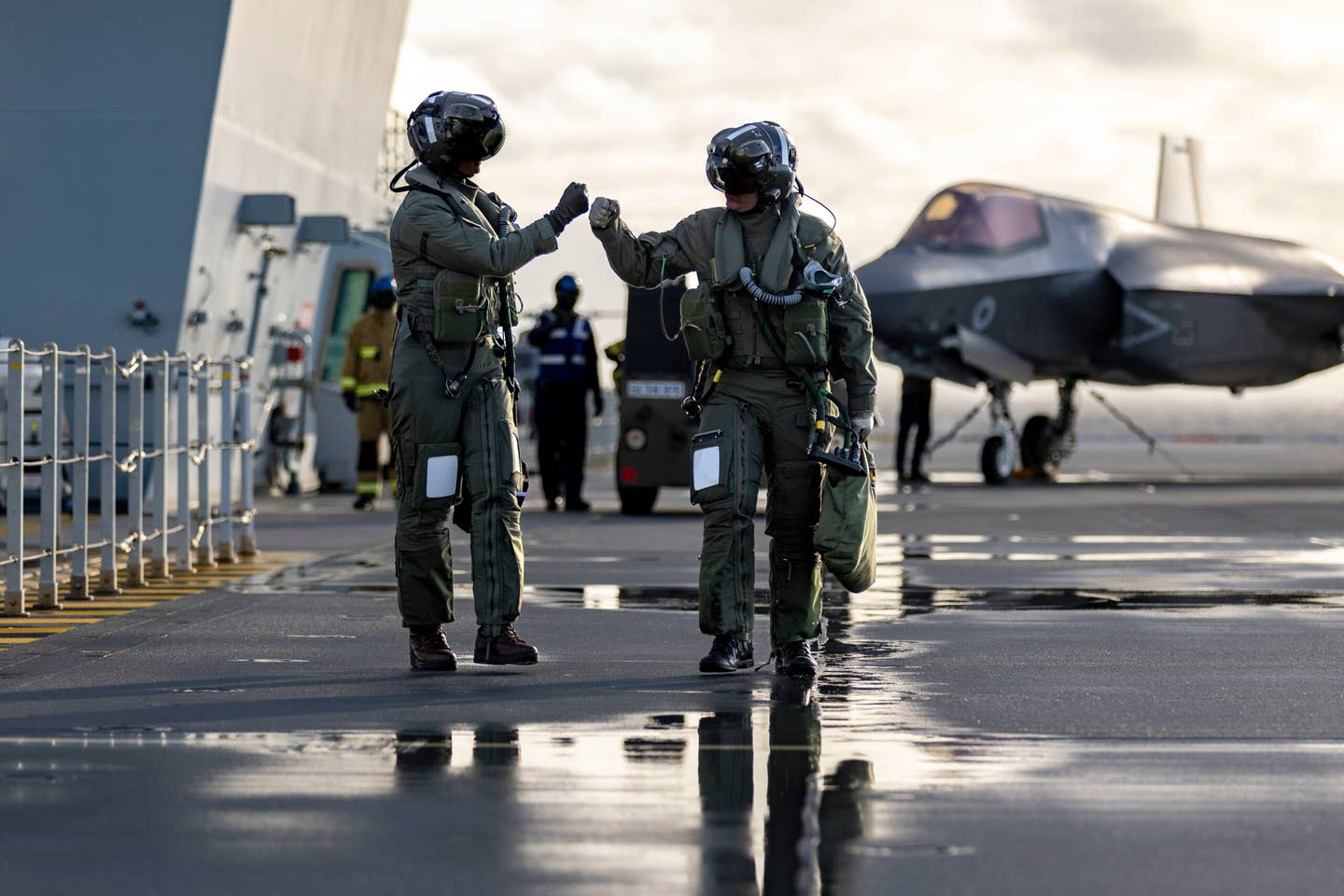 Pilots fist bump on the flight deck of HMS <em>Queen Elizabeth</em> during Exercise Phoenix Strike, a Norwegian-led exercise integrating fifth-generation fighters and Norwegian special forces, in October 2023. <em>Crown Copyright</em>