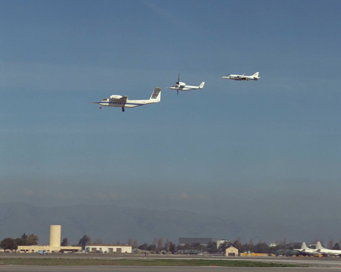 A March 1987 NASA Ames airshow includes three different STOL and VSTOL test aircraft: the QSRA, XV-15 tilt-rotor, and AV-8B Harrier II in flight formation. <em>Roger Brimmer</em><br>