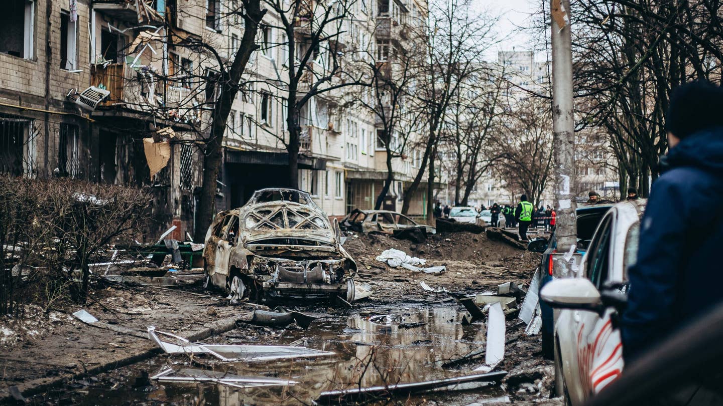 A wrecked, burned-out car lies in the yard of a high-rise residential building in Dniprovskyi district after a missile explosion on December 13, 2023 in Kyiv, Ukraine. For the second night in a row, Russia is attacking Kyiv with ballistic missiles. All ten missiles were intercepted by Ukrainian Air Defense Forces. However, fallen missiles' fragments resulted in destruction in Darnytskyi, Dniprovskyi and Desnyanskyi districts of Kyiv.