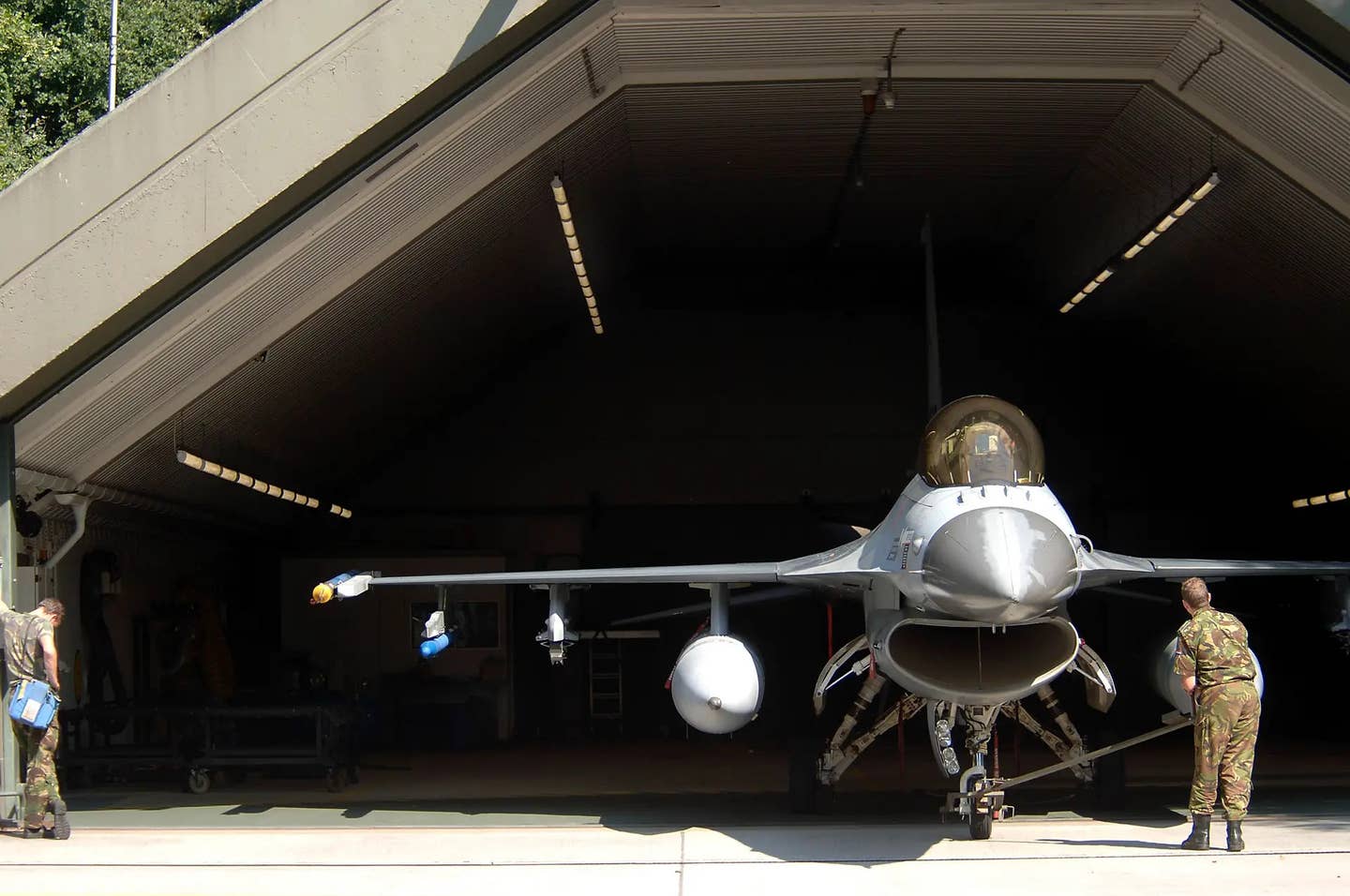 A stock picture of a Dutch F-16 inside a hardened aircraft shelter at Volkel Air Base. <em>USAF</em>