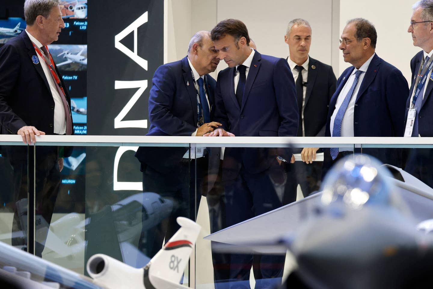 French President Emmanuel Macron speaks with Dassault Aviation CEO Eric Trappier (left), in front of a model of the Dassault Rafale, as he visits the International Paris Air Show in June 2023. <em>Photo by LUDOVIC MARIN/POOL/AFP via Getty Images</em>