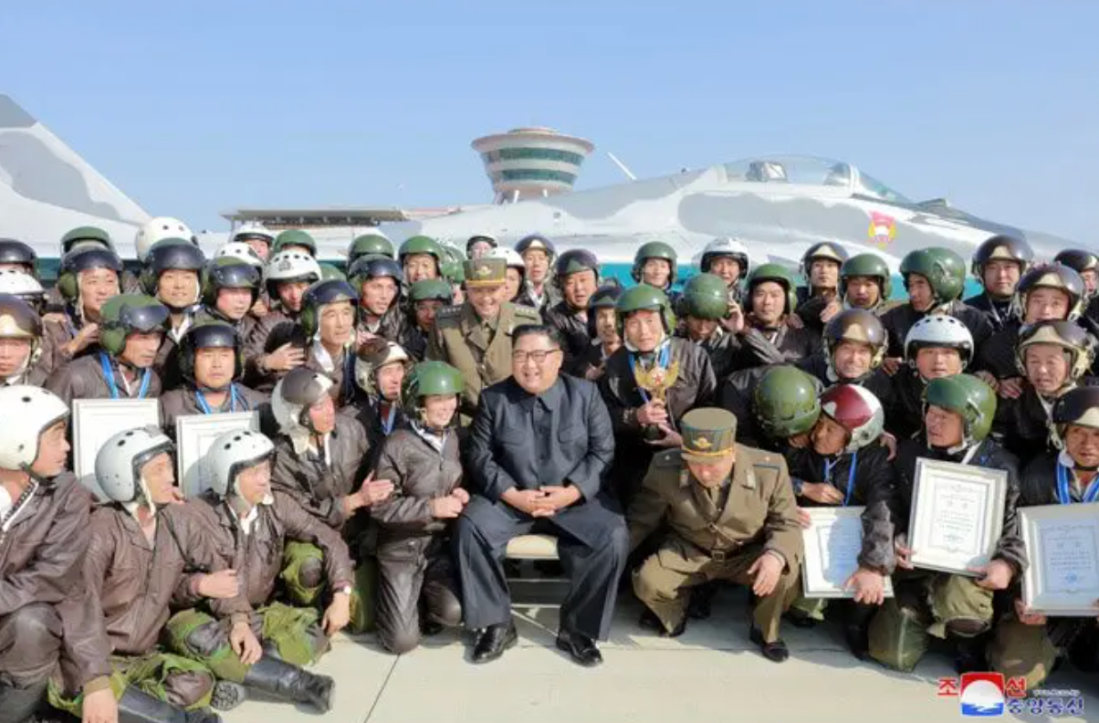 Supreme leader of North Korea Kim Jong Un poses with KPAF aircrew in front of a MiG-29.<em> NK State Media</em>