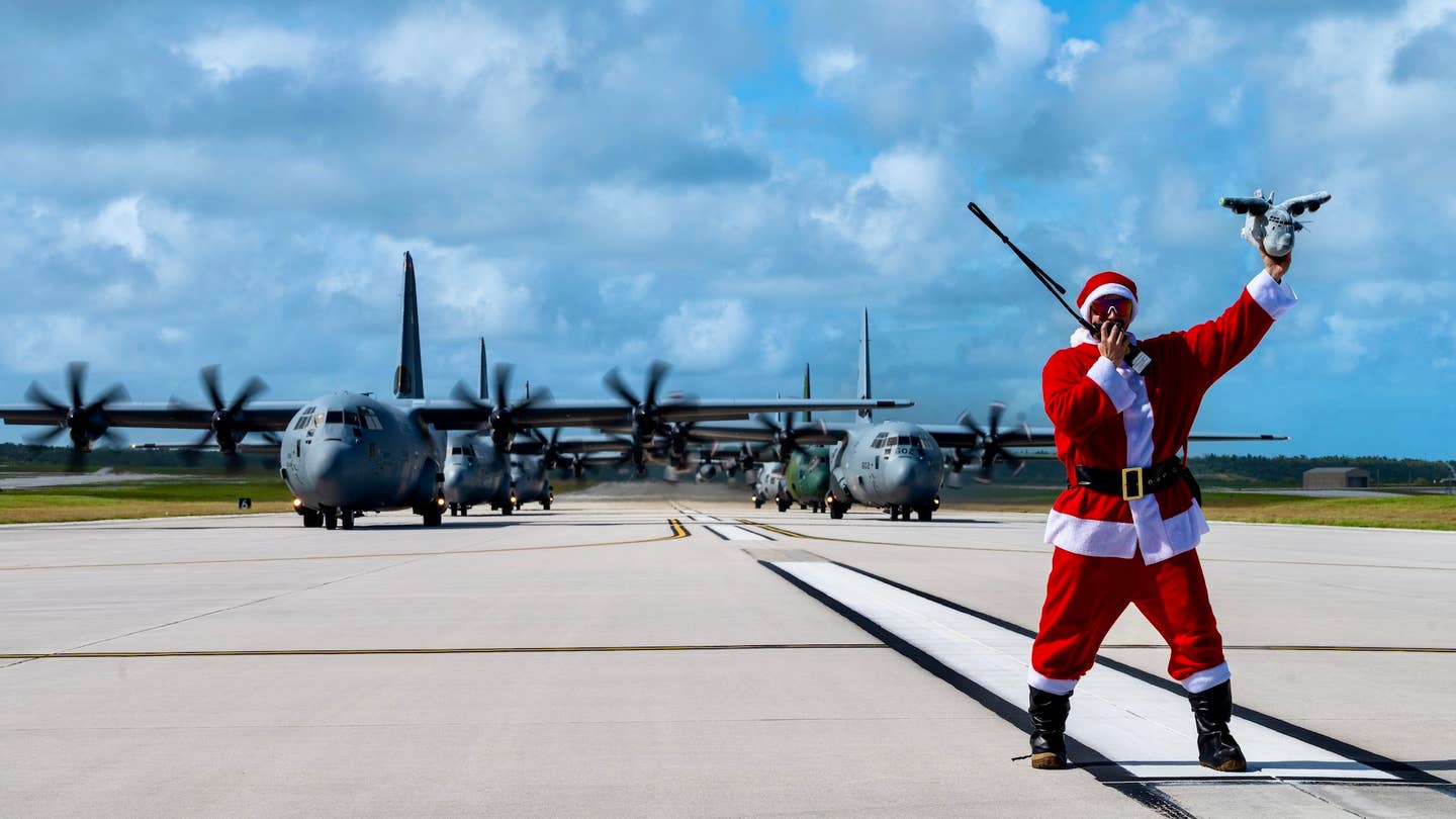 U.S. Air Force Maj. Zach “Santa Badger” Overbey, Operation Christmas Drop 2023 (OCD 23) mission commander and pilot, stands before three U.S. Air Force (USAF) C-130J Super Hercules assigned to the 36th Expeditionary Airlift Squadron, a Royal Canadian Air Force (RCAF) 436th Transport Squadron C-130J Super Hercules, a Japan Air Self-Defense Force (JASDF) C-130H Hercules assigned to the 401st Tactical Airlift Squadron, and a Republic of Korea Air Force (ROKAF) C-130H Hercules assigned to the 251st Airlift Squadron in support of an OCD 23 elephant walk at Andersen Air Force Base, Guam, Dec. 9, 2023. Throughout OCD 23, USAF, RCAF, JASDF, and ROKAF crewmembers delivered 210 bundles to 58 islands over the span of six days. The deliveries of humanitarian aid reached over 42 thousand remote Micronesian islanders across 1.8 million square miles. (U.S. Air Force photo by Senior Airman Brooklyn Golightly)