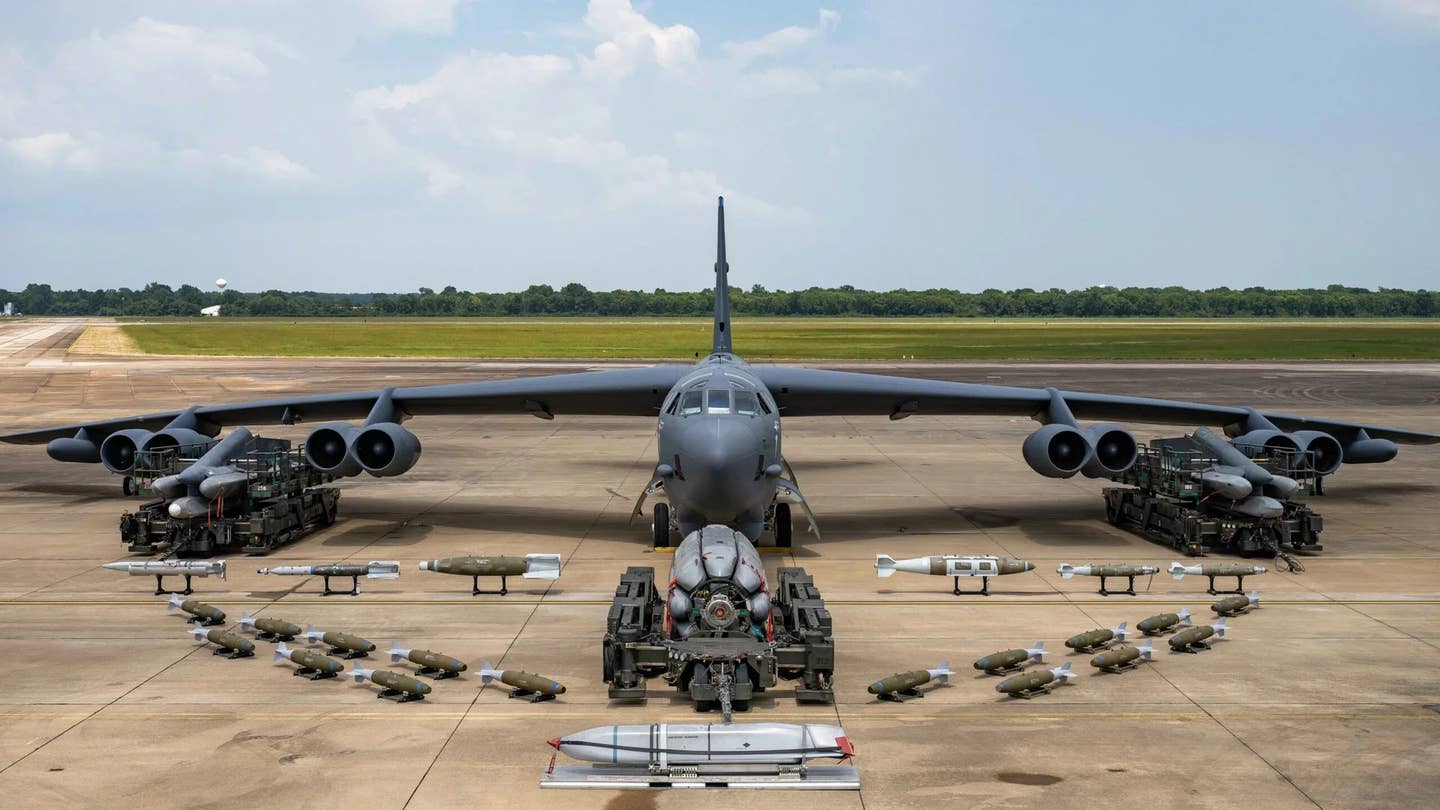 A B-52H bomber with an array of different munitions in front, including AGM-86-series Air-Launched Cruise Missiles (ALCM) on underwing pylons and a rotary launcher that goes in the bomb bay. <em>USAF</em>
