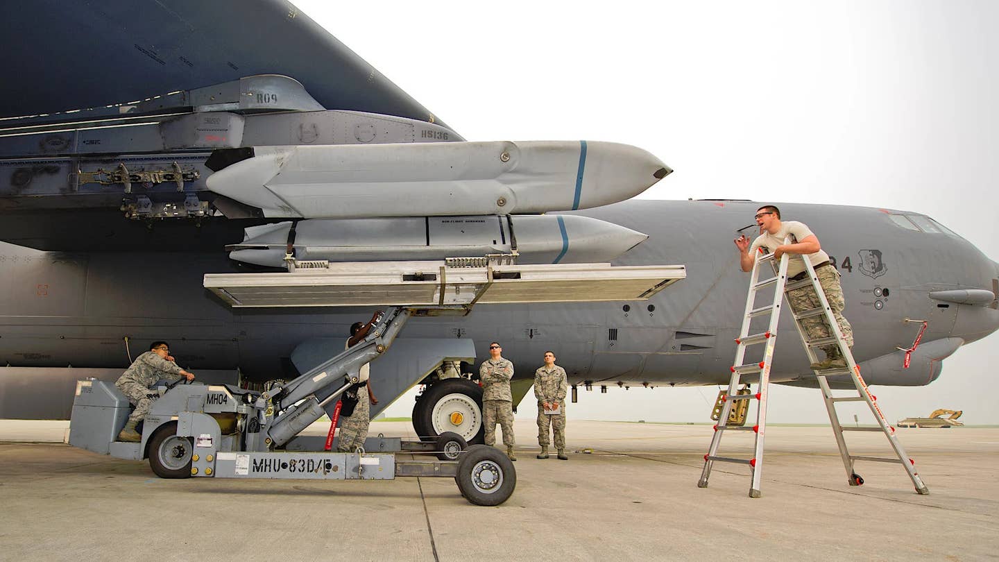 U.S. Air Force personnel load AGM-158 JASSM-series cruise missiles onto pylons under the wing of a B-52.<em>&nbsp;U.S. Air Force</em><br>