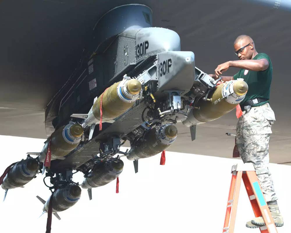 Eight 500-pound-class Joint Direct Attack Munition (JDAM) precision-guided bombs loaded under the wing of a B-52 using the existing Improved Common Pylon. <em>USAF</em>