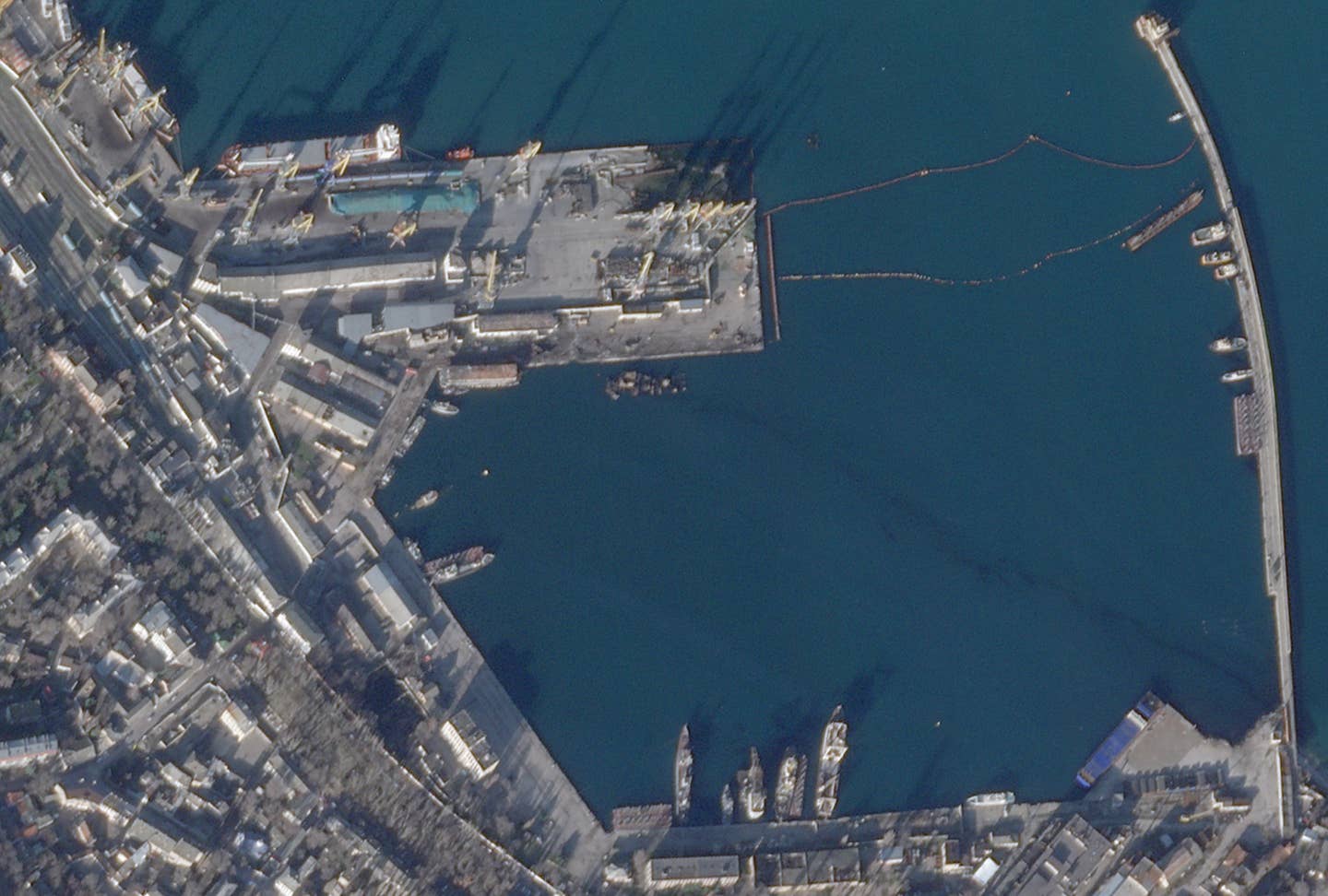 A satellite image of the port of Feodosia in Crimea taken on December 27, showing the aftermath of a Ukrainian missile strike that destroyed the Russian Navy's <em>Ropucha</em> class landing ship <em><em>Novocherkassk</em></em> and caused other damage. <em>PHOTO © 2023 PLANET LABS INC. ALL RIGHTS RESERVED. REPRINTED BY PERMISSION</em>