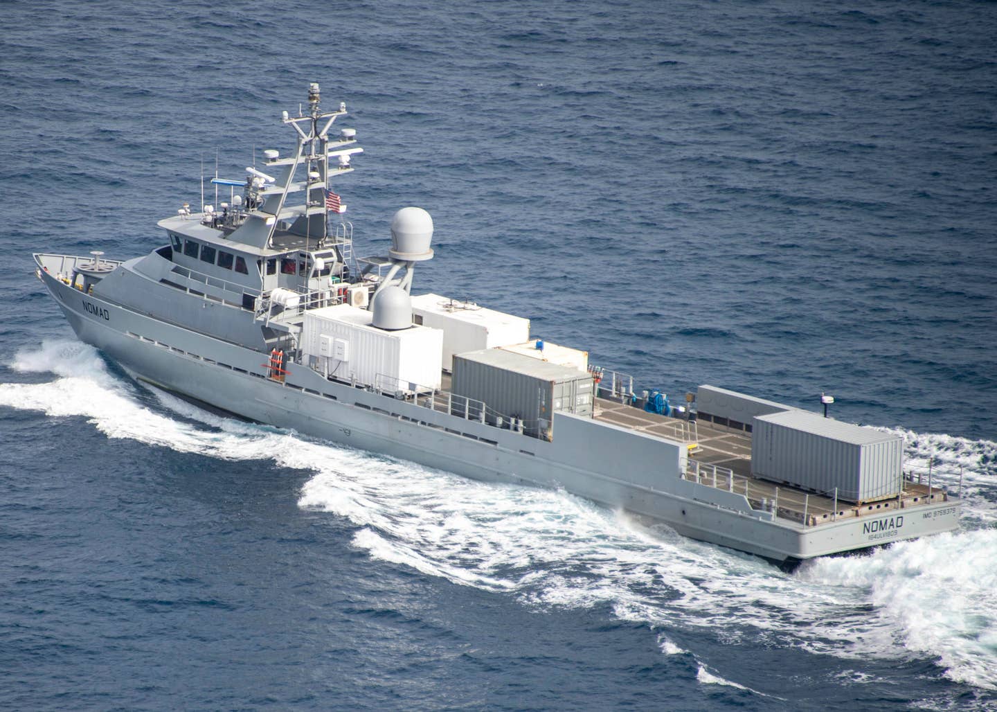 A picture of Nomad sailing in the Pacific in 2022 with the antenna dome fitted and the mast festooned with radars, sensors, and other equipment. <em>USN</em>