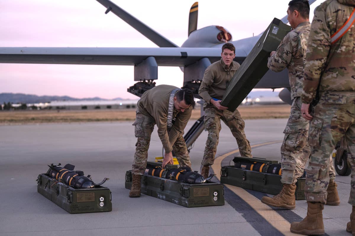 Members of the 163rd Attack Wing load AGM-114R Hellfire missiles onto an MQ-9 as part of the mission to support MDA's FTG-12 test. <em>Air National Guard</em>