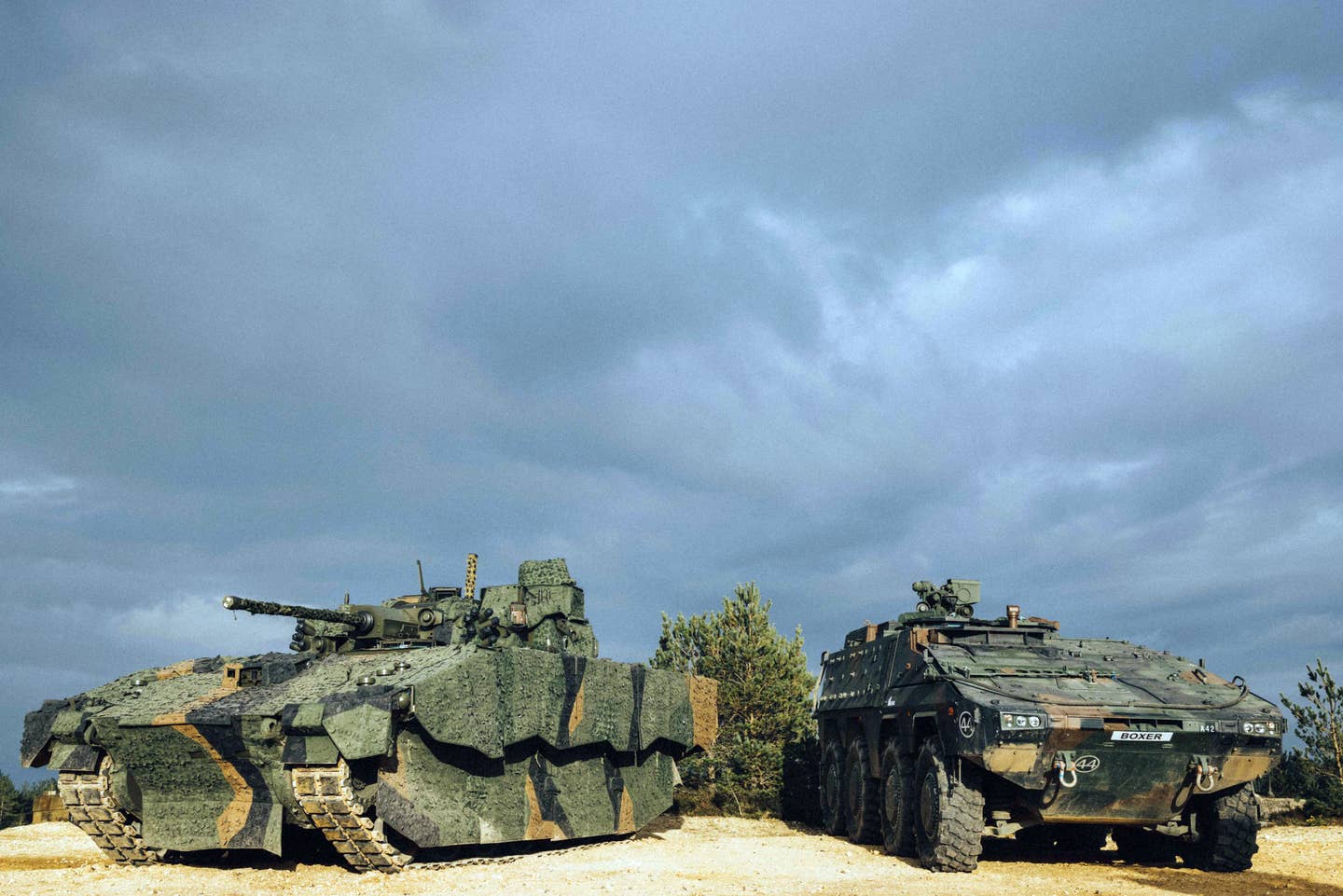 Ajax (left) and Boxer side by side during a demonstration of British Army capabilities on the training area at Bovington Camp, England. <em>Crown Copyright</em>